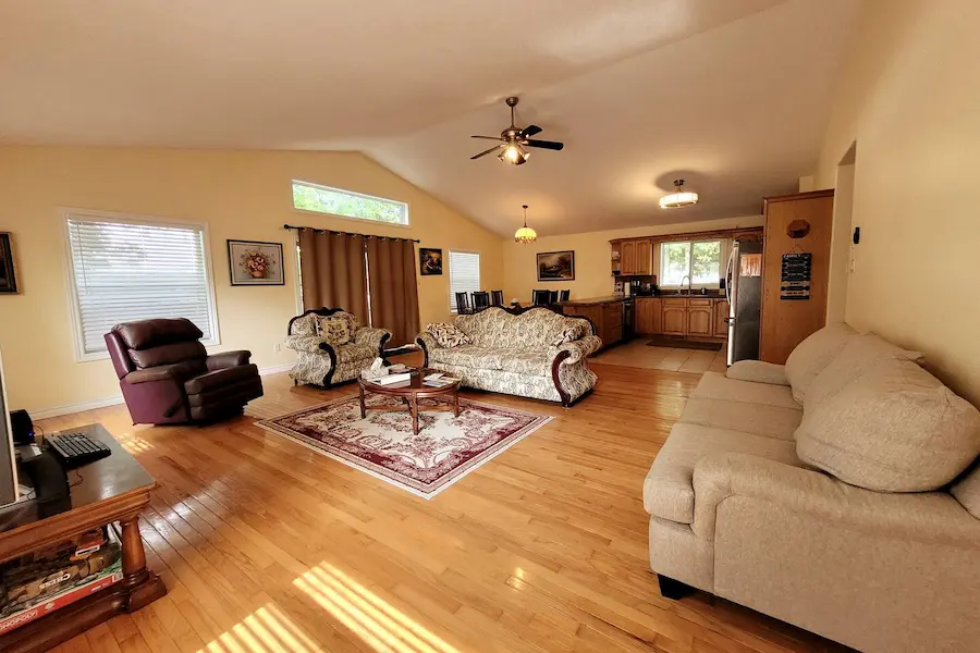 Spacious open-concept living room with hardwood floors and vaulted ceilings